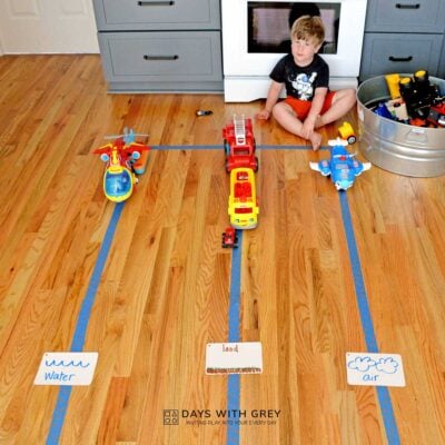 Preschooler sorting transportation toys for water, land, and air.