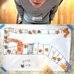 Overhead shot of a DIY board game to help preschoolers count using mini erasers.