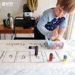 Preschooler using Unifix Cubes to build their phone number on paper.