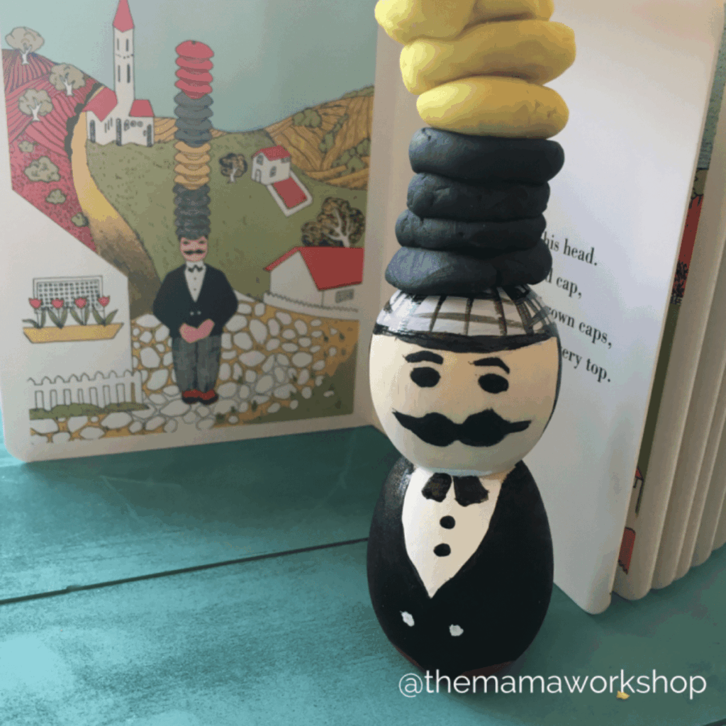 Play dough caps on a wooden man to represent the peddler in Caps for Sale.