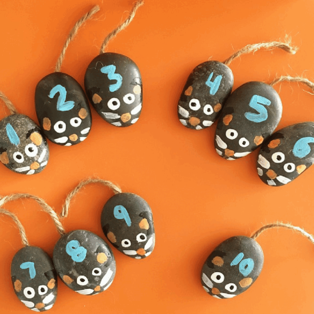 Little mice made from flat stones with painted features and numbers.