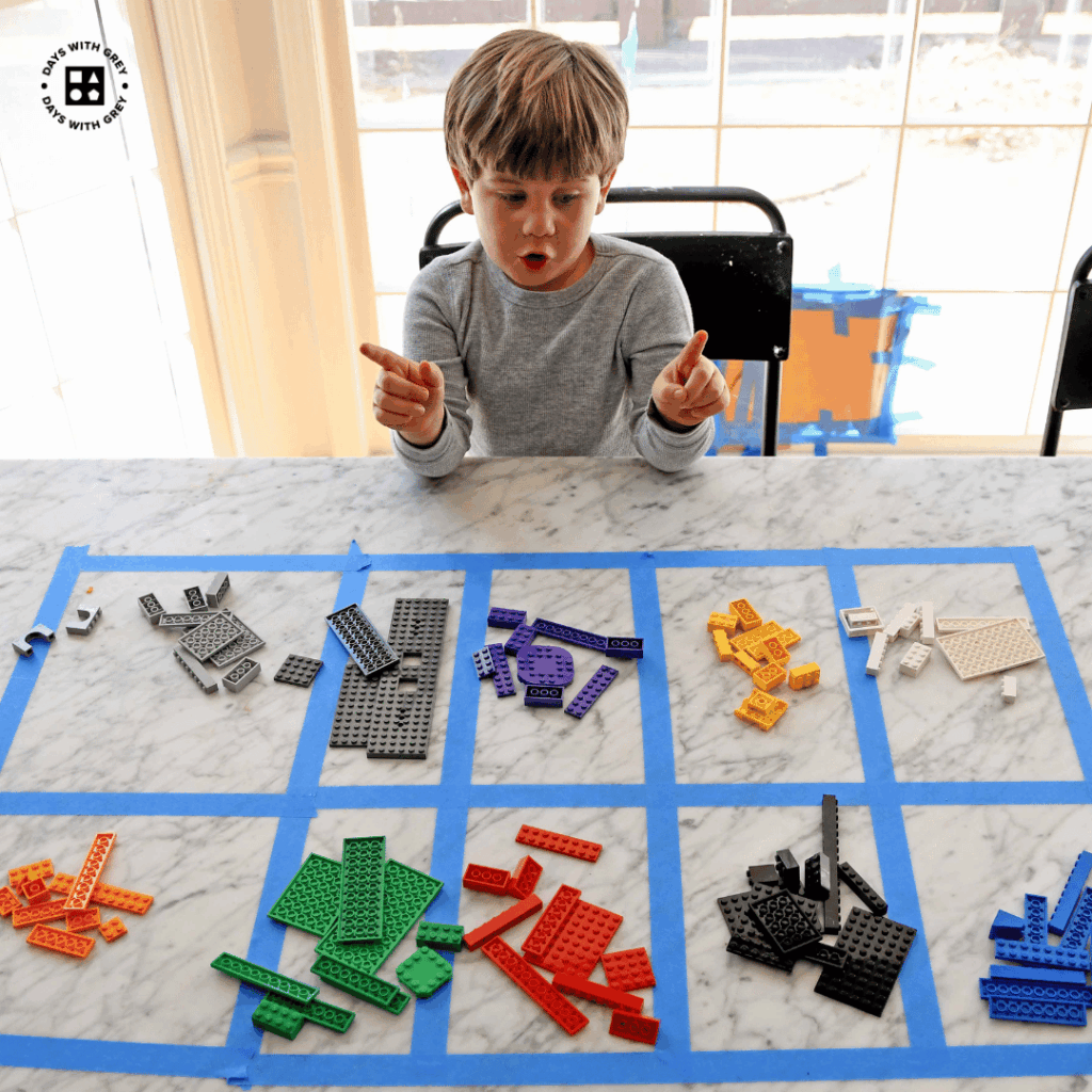 Five year old thinking about what to do with the 100 Legos in front of him.