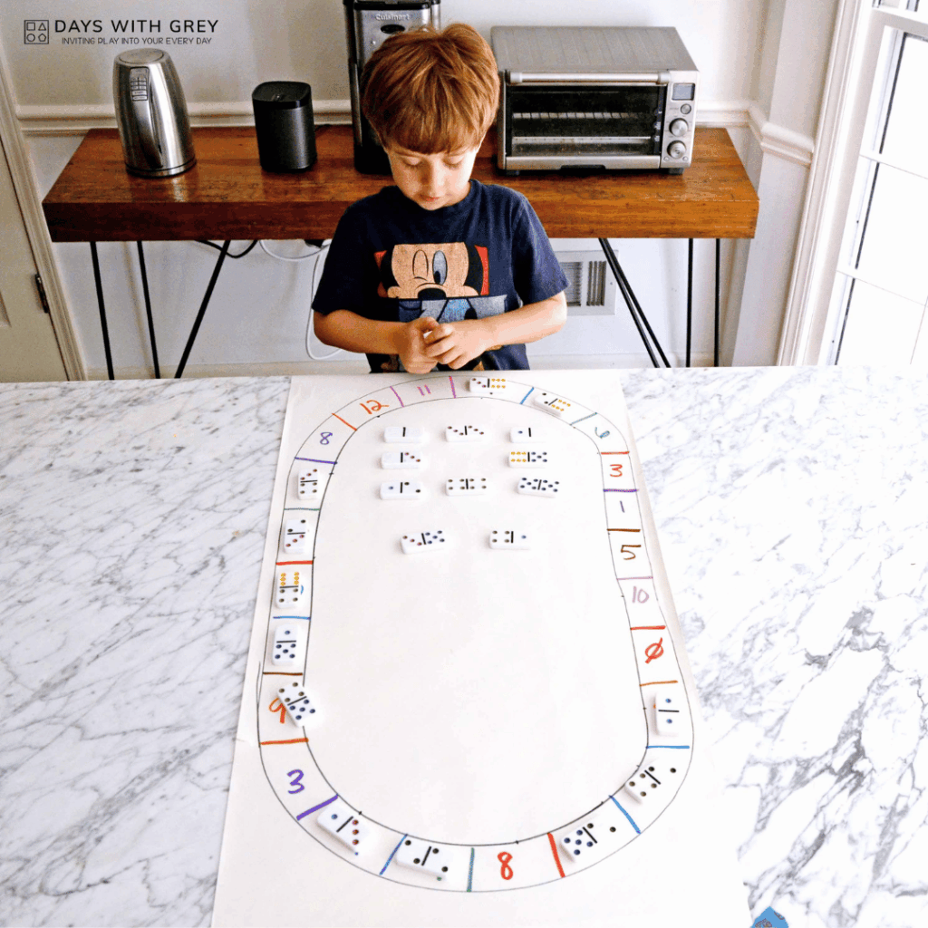 A five year old adding the dots on the dominos.