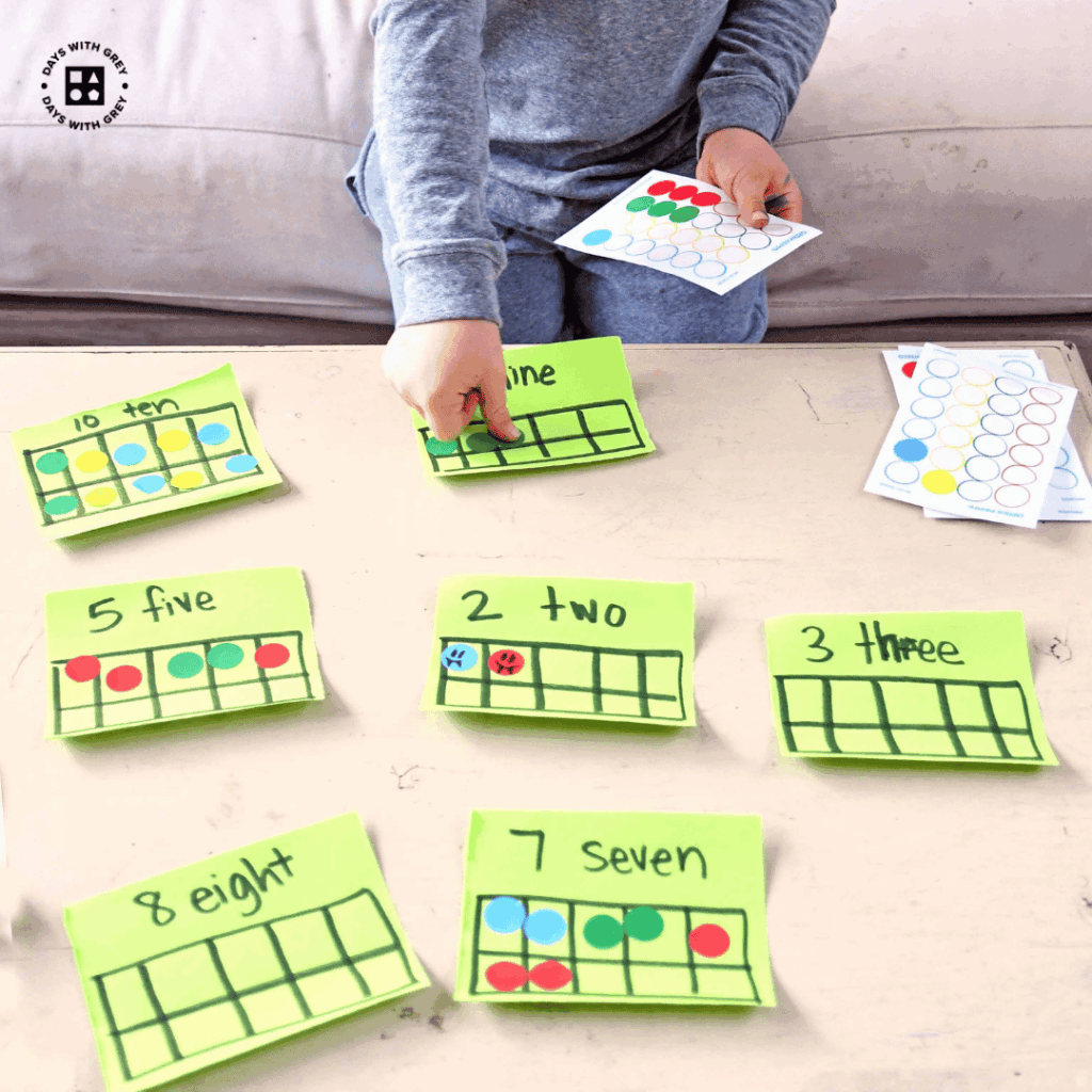 A five year old making ten frames with small paper and dot stickers.