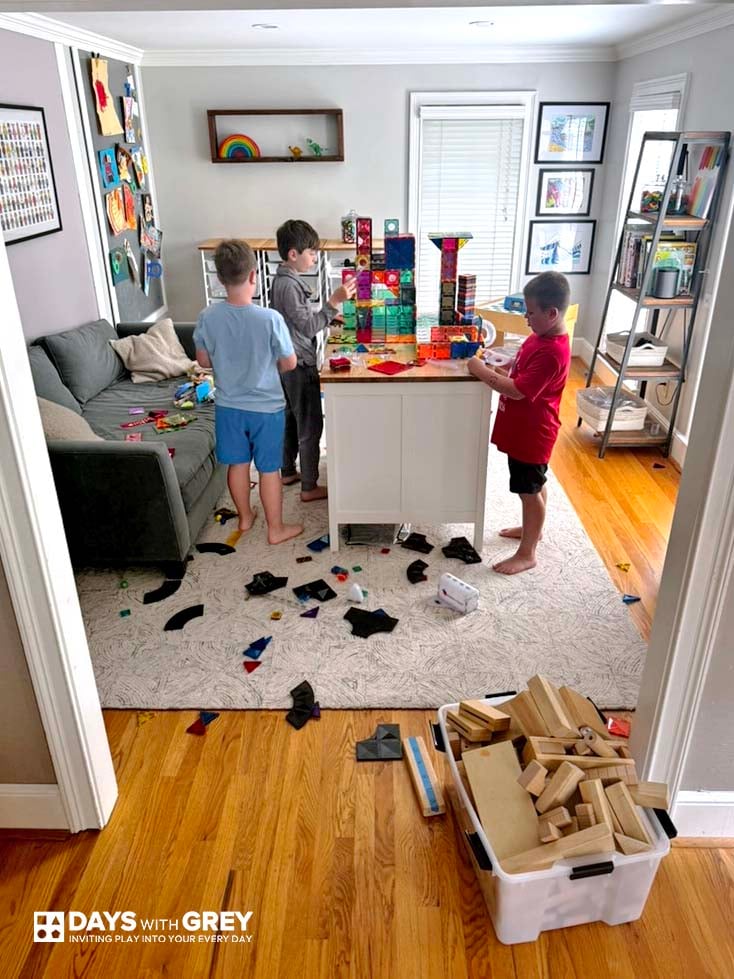 Kids in a screen-free room playing together with magnetic tiles.