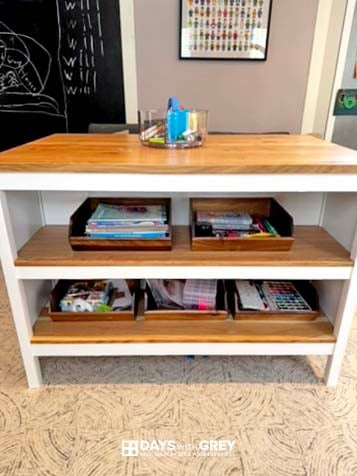 The back of the freestanding art table for kids in their playroom. It has organized art storage.